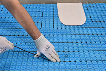 A heated floor using Prodeso and ComfortTile heat cable being installed in bathroom.